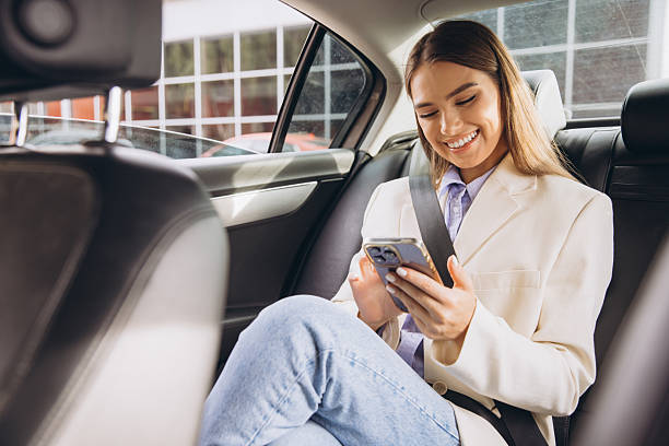 istock Smiling Woman Using Smartphone While Traveling in Car 2243172846