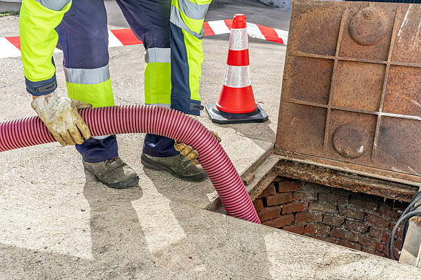 istock Sewer worker draining wastewater from street manhole 2243183295