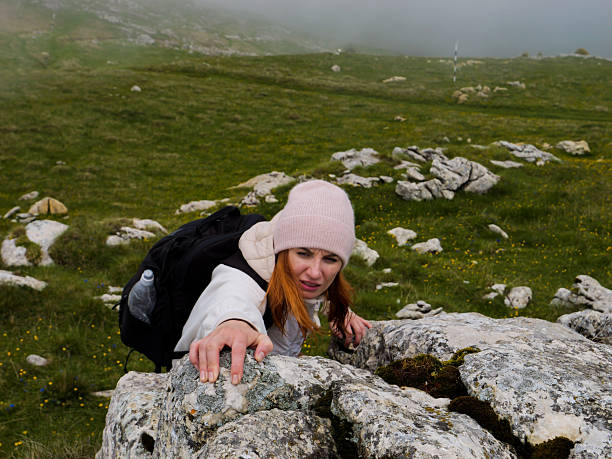 Rock climbing outside in summer. Young Teen Climbing On The Mountain During Summer Vacation Travel Hike. Hiker Hiking Climbing. Woman Hiking Climbing Mountain. Girl climbs up the side of a mountain.