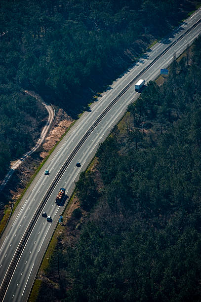 istock Highway view showing vehicles and lush forest in a remote area during daytime 2243196775