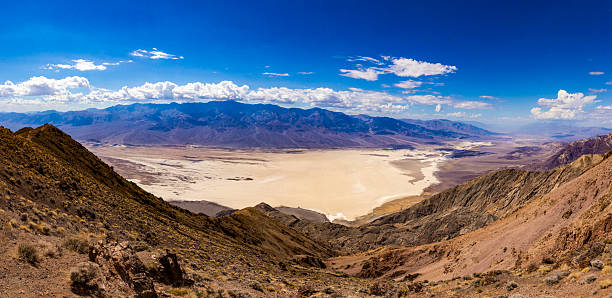 Death Valley, located in eastern California near the Nevada border, is one of the hottest and driest places on Earth. It lies within the Mojave Desert and is known for its extreme temperatures, often exceeding 50°C (122°F) in summer. The valley is also the lowest point in North America, at Badwater Basin, which sits 282 feet (86 meters) below sea level. Despite its harsh environment, Death Valley features striking natural beauty, including salt flats, sand dunes, colorful rock formations, and rare desert flora and fauna. It is part of Death Valley National Park, attracting visitors worldwide for its dramatic landscapes.