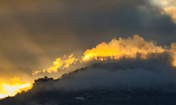 istock Golden clouds and mist over Madeira mountain ridge 2243200147