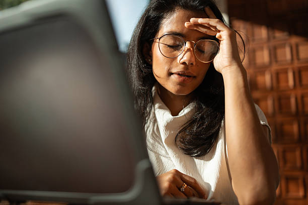 istock Woman experiencing headache and stress working remotely on laptop 2243205433