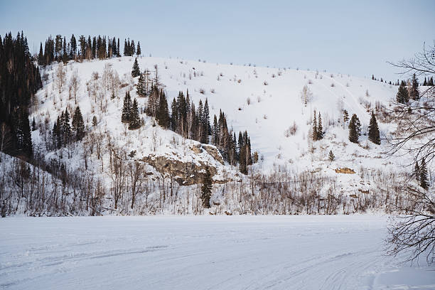istock A picturesque snowy mountain rises majestically, adorned with tall trees along its rugged sides, while a tranquil lake glimmers in the foreground, creating a scenic winter landscape 2243211962