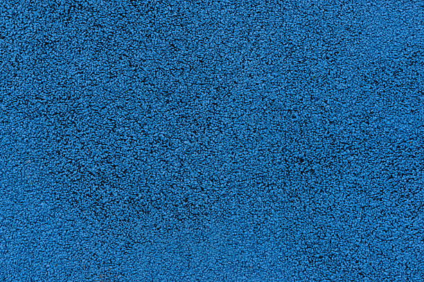 A close-up view shows the rough texture of a blue rubber safety floor.