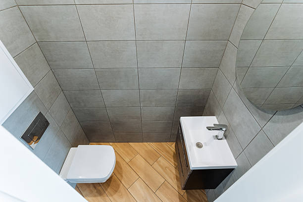 istock This compact bathroom design maximizes space with essential fixtures like a toilet, sink, and a stylish mirror, ensuring a functional layout that meets modern needs and aesthetics 2243212801