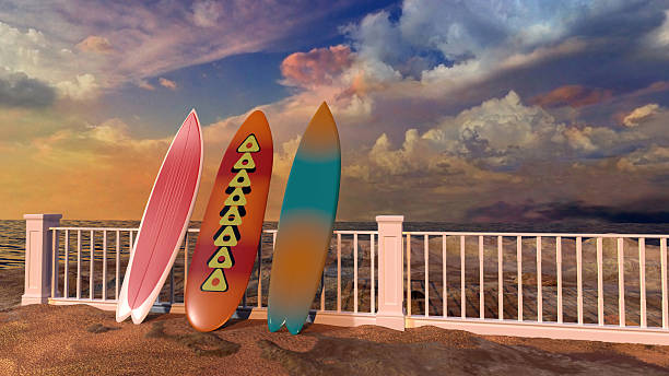 Surfboards leaning against a fence on the seashore, in a sunset of colorful clouds