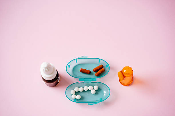 istock A bright blue container overflowing with assorted pills and a medication bottle creates a striking visual contrast against a bold pink background, capturing attention instantly 2243215523