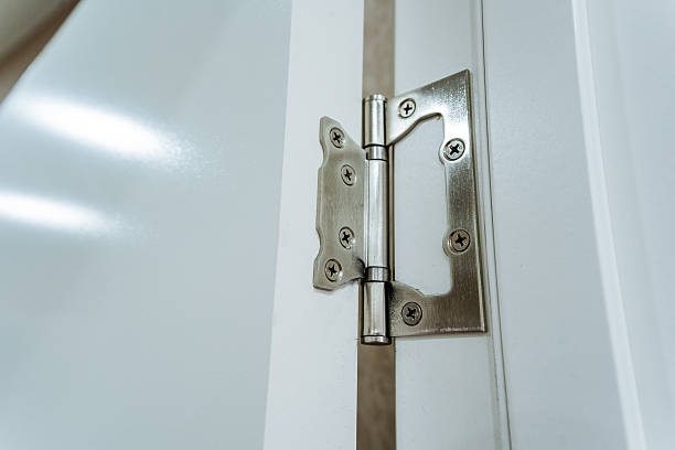 istock This closeup image showcases a meticulously crafted door hinge affixed to a pristine white door, highlighting its intricate design that ensures smooth and flawless operation when used 2243216688