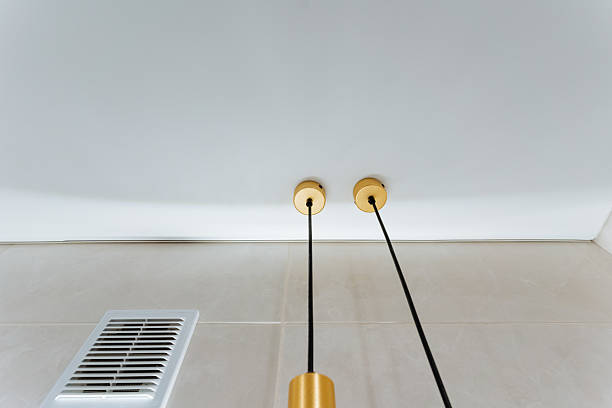 istock This is a detailed closeup image showcasing a ceiling that features two distinct lights elegantly hanging down from it, highlighting the design and aesthetic of the space 2243216689