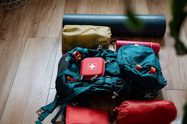 istock A red first aid kit is placed inside a backpack that is resting on a wooden floor, conveniently positioned beside a yoga mat, ready for use or emergency assistance when needed 2243216757