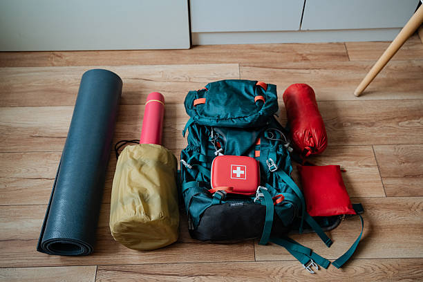 istock A backpack, a yoga mat, a sleeping bag, and a first aid kit can currently be found scattered across the floor in the room. These items seem to be waiting to be organized 2243216763