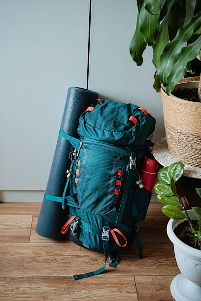 istock A vibrant blue backpack can be seen resting on a beautifully polished wooden floor, positioned right next to a neatly rolledup yoga mat that adds a touch of calmness to the space 2243217294