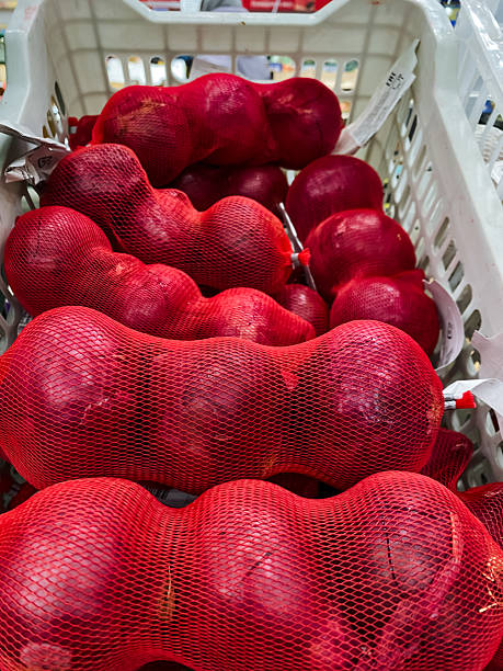 There is a delightful bunch of fresh, red apples placed carefully in a woven basket, showcasing their vibrant color and appealing appearance, perfect for snacking or baking