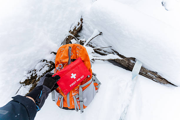 istock A person is holding a first aid kit next to a backpack in the snow 2243218306