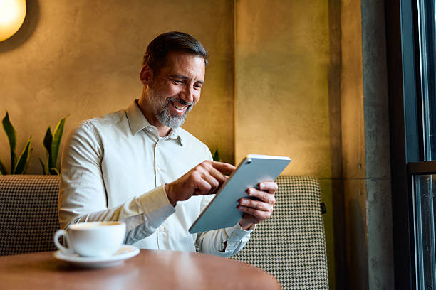istock Mature businessman working remotely using tablet in coffee shop 2243236721
