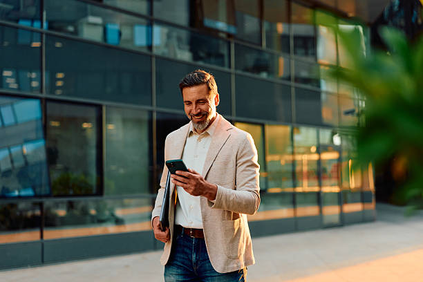 Businessman walking in urban street using phone