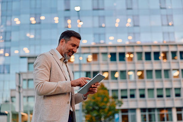 istock Mature adult businessman smiling while using digital tablet 2243236997