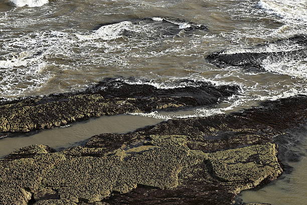 A coastline where waves crash against a rocky shore