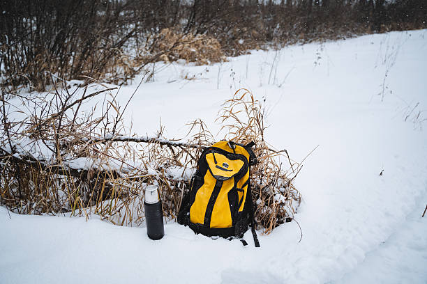 istock A bright yellow backpack rests alone in the freshly fallen, glistening snow, alongside a cold water bottle, creating a striking and vivid contrast against the pure white winter surroundings 2243243529