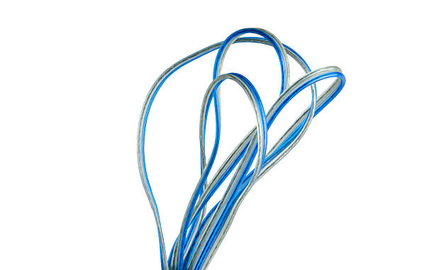 Blue and silver electrical wire looped and isolated on white. The photograph provides a clear graphic element representing communication, power, and technical wiring systems.