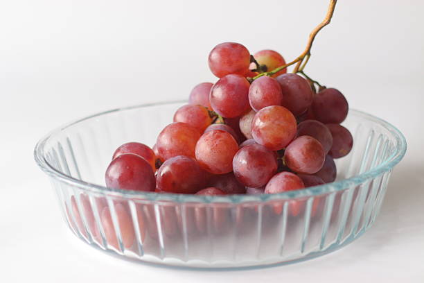 istock Red table grapes in a clear glass bowl, featuring Red Globe, Crimson Seedless, or Flame Seedless 2243246707