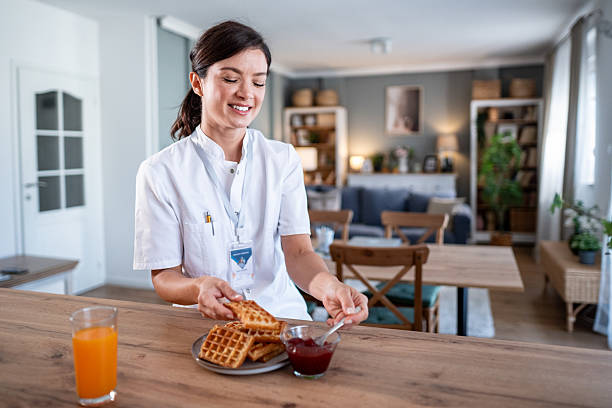 istock Female nurse enjoying breakfast waffles with jam and orange juice 2243256190