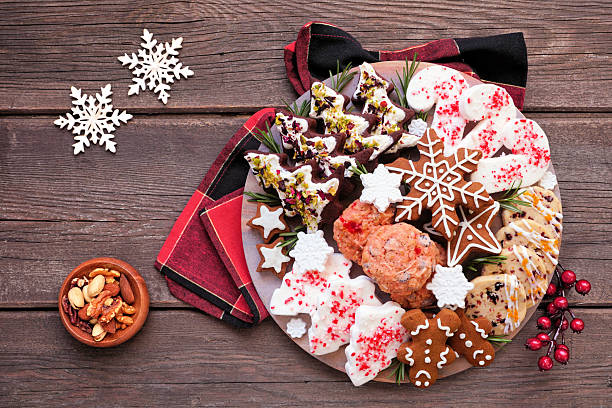 Christmas cookie platter. Top down view table scene on a dark wood background. Holiday baking concept.