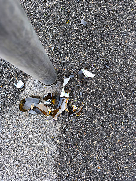 istock Broken glass bottle shattered on asphalt next to a metal pole 2243258779