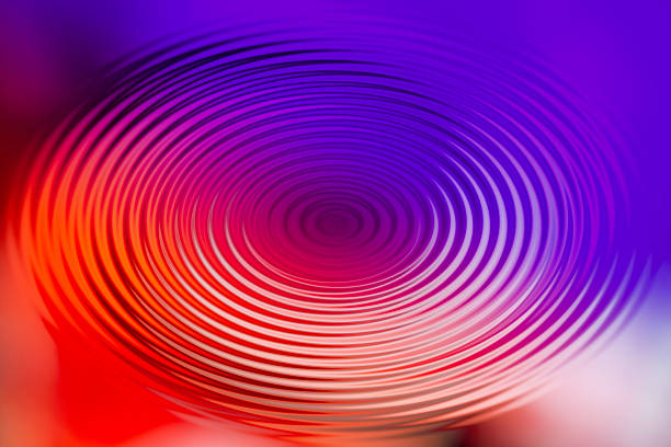 XXXL photo macro of a neon colored spring on a white background.  Selectiv focus on the upper left...the spring has stripes of color in rainbow pastell.