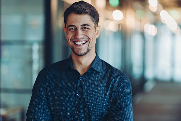 istock Happy young man standing in a modern office space 2243267504