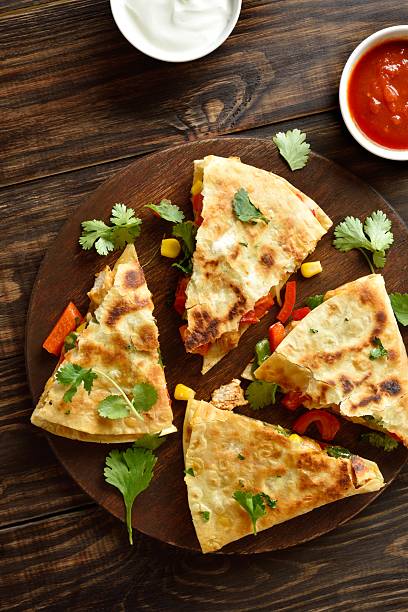 Quesadilla with fresh vegetables on wooden table