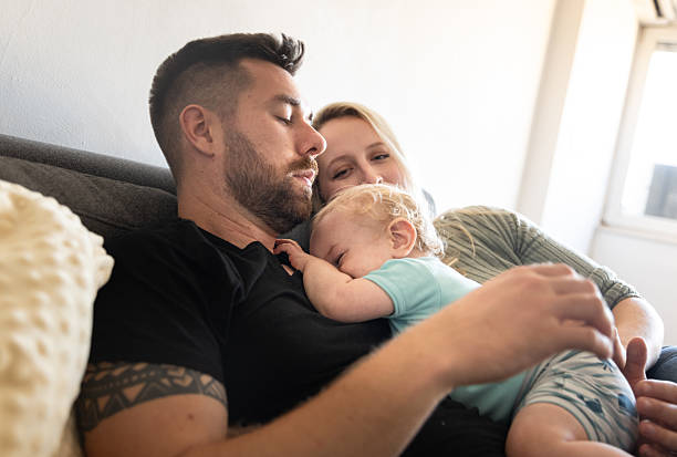 istock Parents Try Napping On The Sofa With Their Baby 2243276335