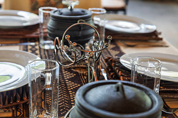 dining table set with traditional Batswana cuisine main dish is served in a traditional three-legged cast iron pot potjie or potjiekos