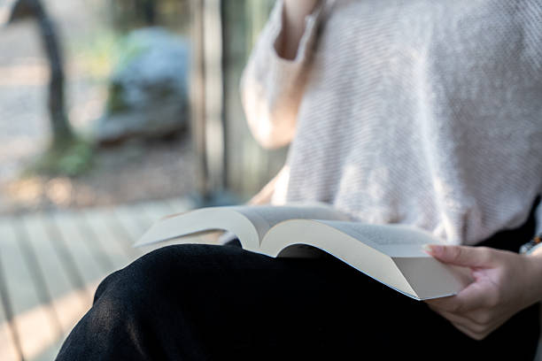 istock Woman reading a book outdoors 2243278310