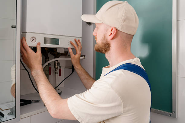 istock Repairman performs maintenance on gas boiler in modern bathroom setting 2243279964