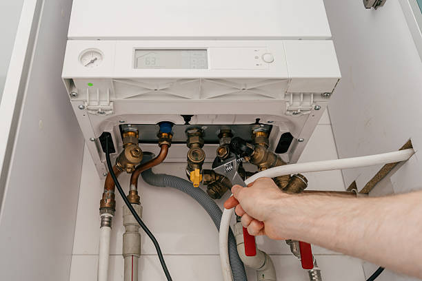istock Repairman fixing modern gas boiler in utility room for efficient heating 2243279970
