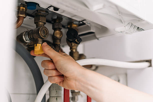 istock Repairman fixing modern boiler in utility room with a wrench and tools 2243281149