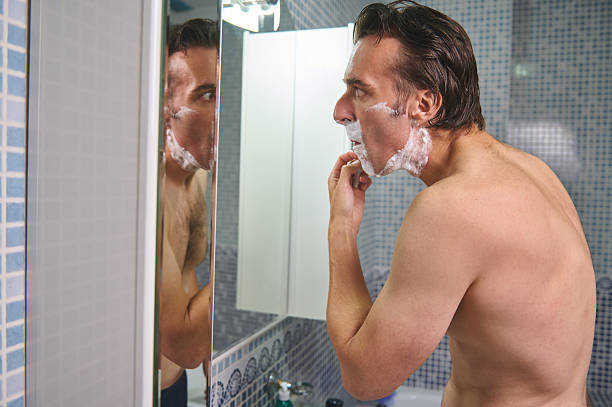 istock Man Shaving in Bathroom, Applying Foam, Looking in Mirror, Grooming Routine 2243281244