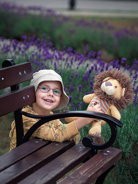 istock Playful boy with toy lion behind park bench 2243281358