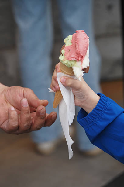 istock Child receiving an ice cream cone on a sunny day 2243282640