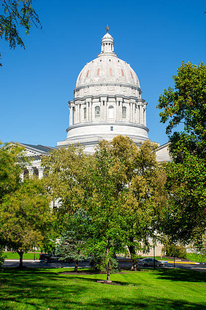The Baroque dome, modeled after St. Peter’s basilica in Rome, of the Missouri State Capitol rises above a green lawn and trees. The dome is topped by sculptor Sherry Fry’s bronze statue of Ceres, the Roman goddess of agriculture.