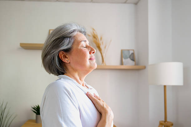 istock Mature adult woman practicing deep breathing meditation 2243290100