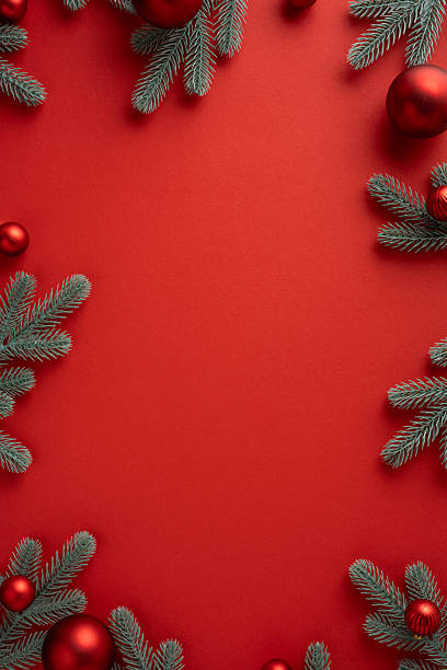 istock Vertical festive red background with pine branches ornaments creating warm seasonal mood for Christmas NewYear greeting and celebration 2243294795