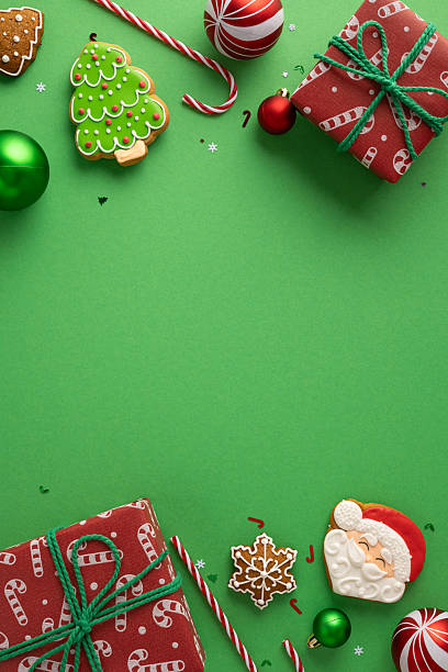 istock Vibrant vertical Christmas theme featuring wrapped presents, decorated cookies, candy canes, and colorful ornaments arranged on a bright green backdrop 2243294910