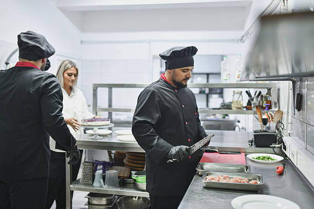 istock Professional Chefs In A Modern Kitchen Preparing Fresh Food And Chopping Ingredients 2243295846