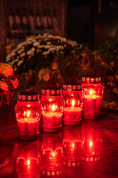 istock Red memorial candles burning on a grave in a cemetery at night 2243299227