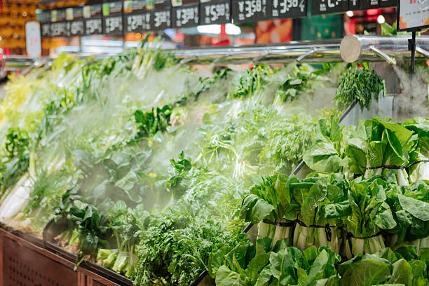 Fresh vegetables covered with cooling mist at local market. Humidified and moisturized produce section symbolizing freshness, natural lifestyle, and organic healthy food concept.
