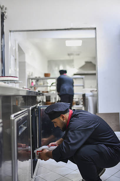 istock Chef Kneeling by the Kitchen Storage Handling Paper Bag in Busy Commercial Kitchen 2243302730