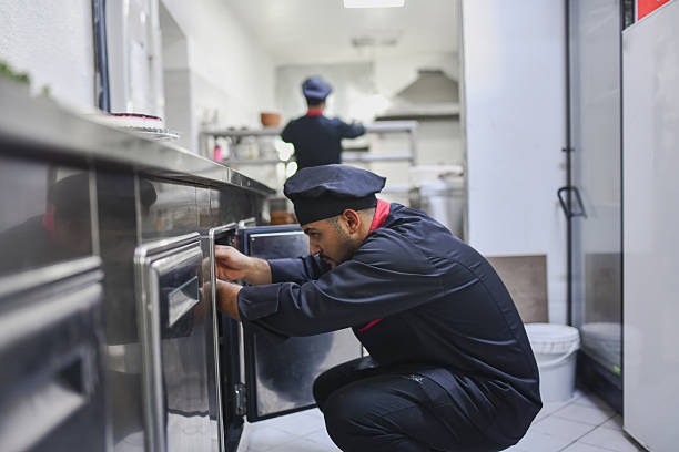 istock Chef Kneeling And Checking Storage In A Professional Kitchen For Efficient Food Preparation 2243302762